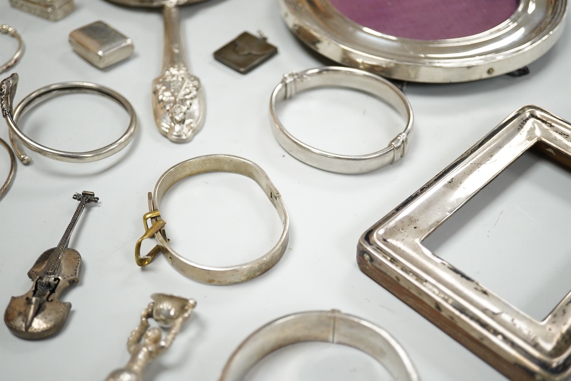 A small group of silver items including a William IV vinaigrette, William Simpson, Birmingham, 1835, 30mm, a later stamp case, two mounted photograph frames, two hinged bangles, together with a group of sterling or white